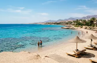 Пляжный курорт на Красном море в Египте с бирюзовой водой, коралловым рифом и зонтиками на песке